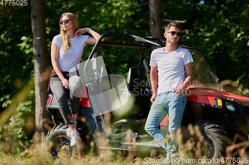 Image of couple enjoying beautiful sunny day while driving a off road buggy