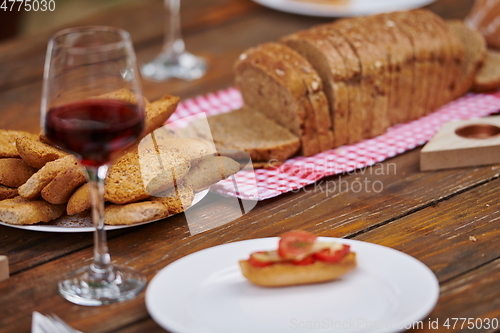 Image of composition with a glass of red wine and toasted bread