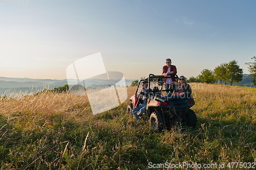 Image of group young happy people enjoying beautiful sunny day while driving a off road buggy car