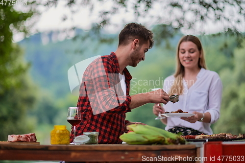 Image of friends having picnic french dinner party outdoor during summer holiday