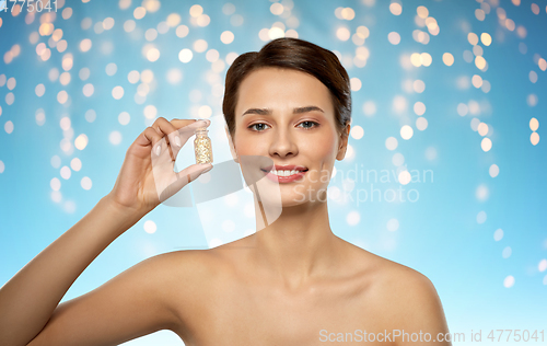 Image of beautiful young woman with gold facial mask
