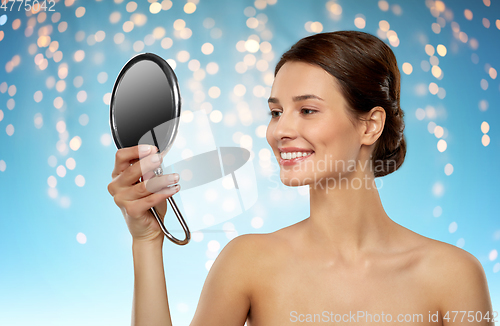 Image of beautiful young woman looking to mirror