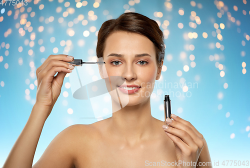 Image of beautiful woman applying mascara