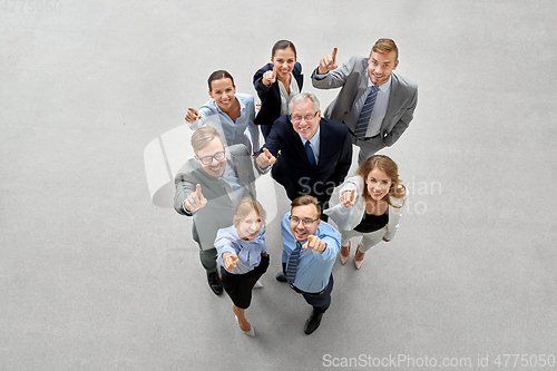 Image of business people pointing fingers up to camera