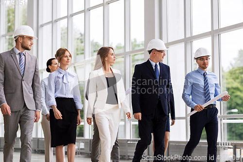 Image of business team in helmets walking along office