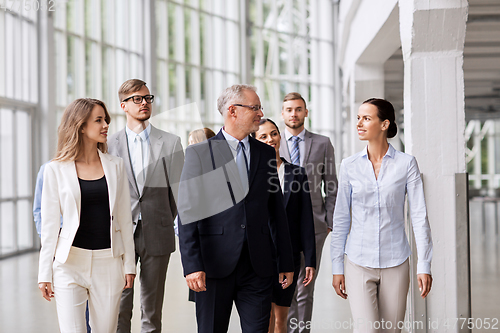 Image of business people walking along office building