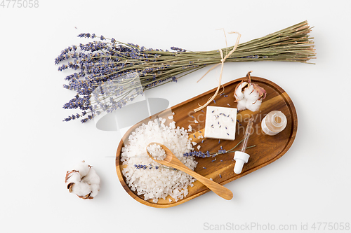 Image of sea salt, lavender soap and serum on wooden tray