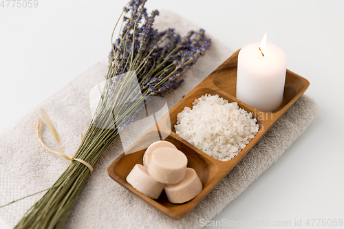 Image of sea salt, soap, candle and lavender on bath towel