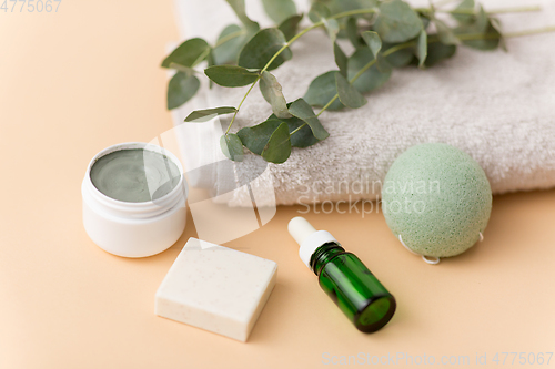 Image of serum, clay mask, oil and eucalyptus on bath towel