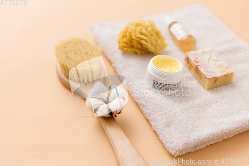 Image of soap, brush, sponge and body butter on bath towel