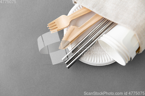 Image of wooden forks, knives and paper cups on plate