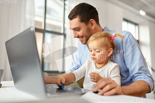 Image of working father with baby daughter at home office