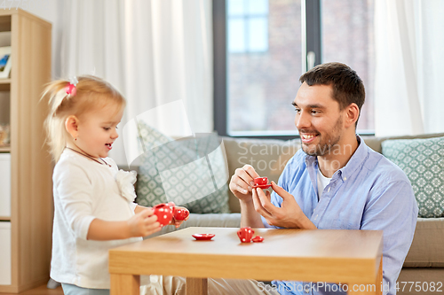 Image of father and daughter playing tea party at home