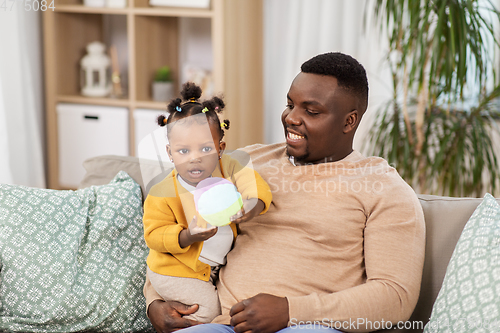 Image of happy african american father with baby at home