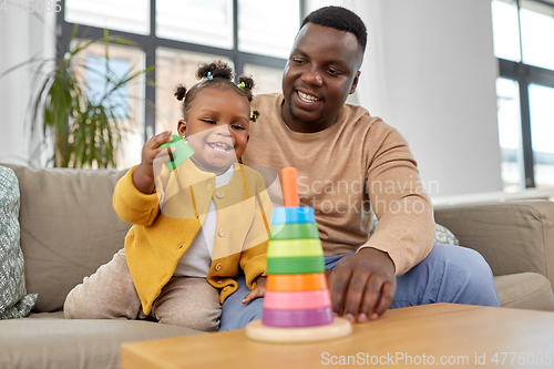 Image of african family playing with baby daughter at home