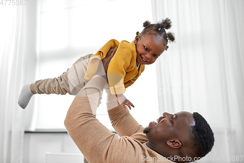 Image of happy african american father with baby at home