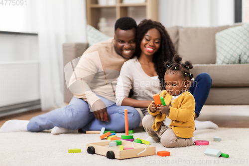 Image of african family playing with baby daughter at home