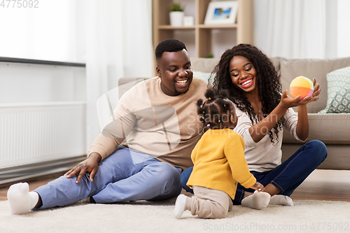 Image of african family playing with baby daughter at home