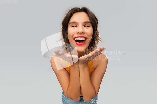 Image of happy smiling young woman in mustard yellow top