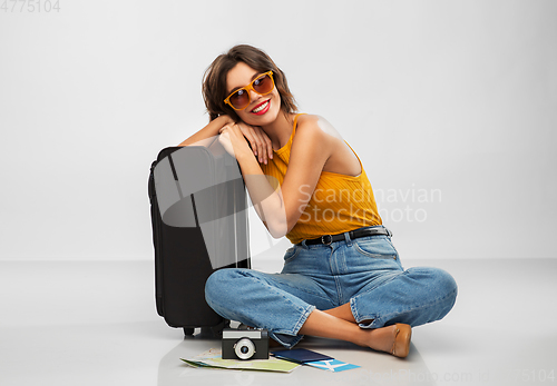 Image of woman with travel bag, air ticket, map and camera