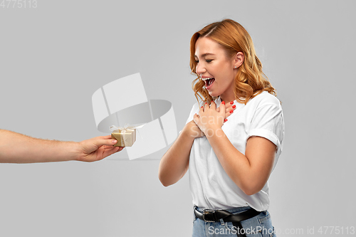 Image of happy couple in white t-shirts with christmas gift