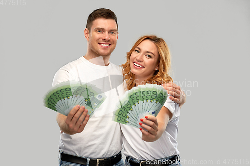 Image of happy couple in white t-shirts with euro money