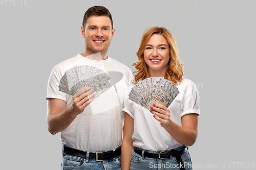 Image of happy couple in white t-shirts with dollar money