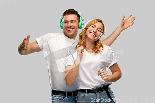 Image of happy couple in headphones dancing