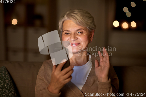 Image of happy old woman with smartphone having video call