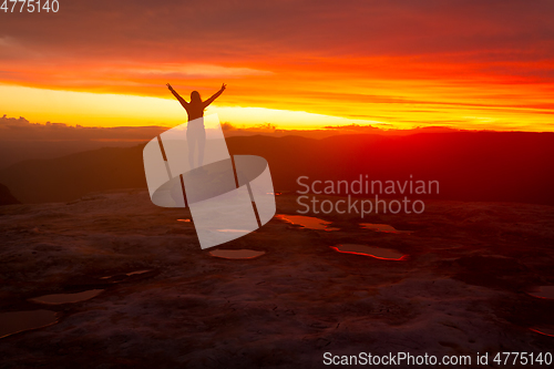 Image of Woman praise glory success silhouette against red sunset sky