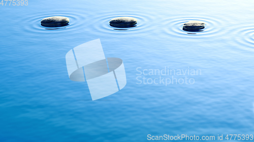 Image of pebble stones in water with ripples background