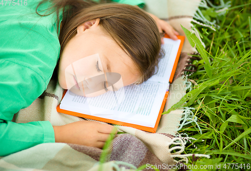 Image of Girl is sleeping on her book outdoors