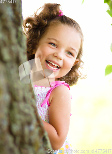 Image of Cute little girl is playing hide and seek