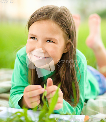 Image of Portrait of a little girl laying on green grass