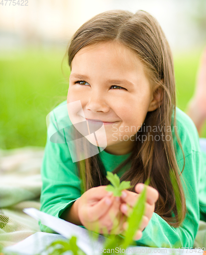 Image of Portrait of a little girl laying on green grass
