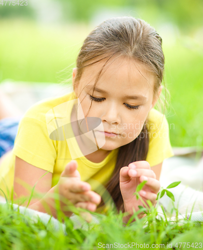 Image of Portrait of a little girl laying on green grass