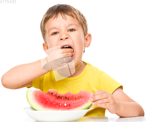 Image of Little boy is eating watermelon