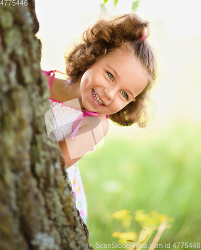 Image of Cute little girl is playing hide and seek