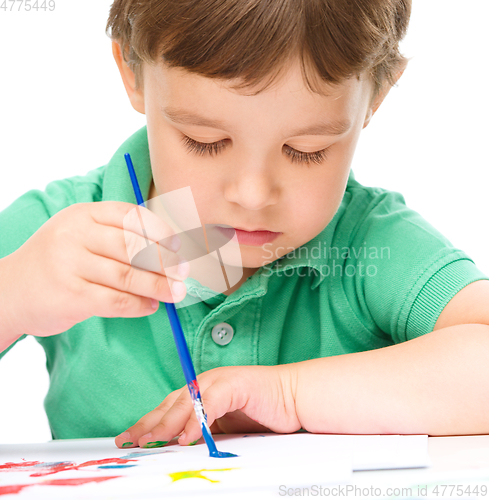 Image of Little boy is playing with paints