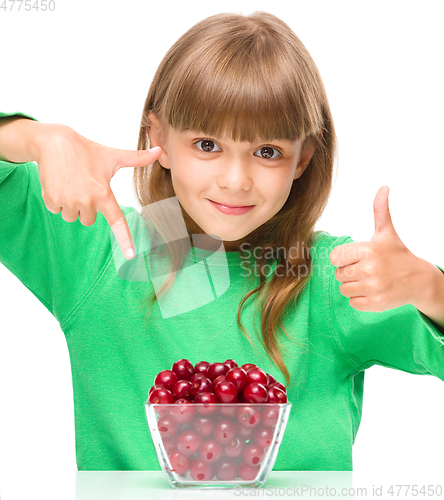 Image of Cute girl is eating cherries showing thumb up sigh