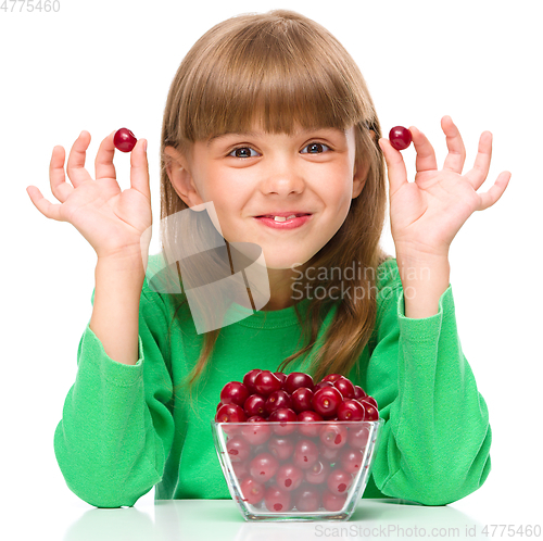 Image of Cute girl is eating cherries