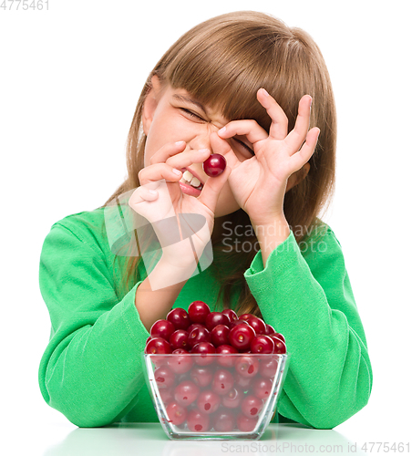 Image of Cute girl is eating cherries