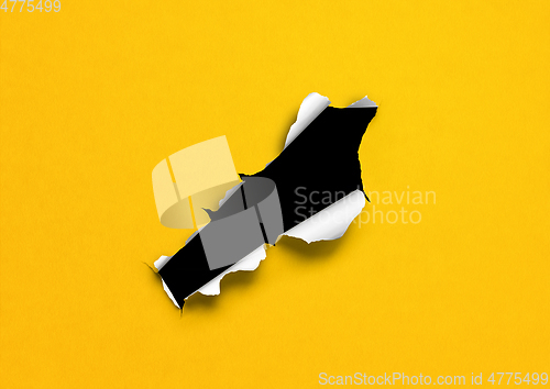 Image of Yellow torn paper with black hole