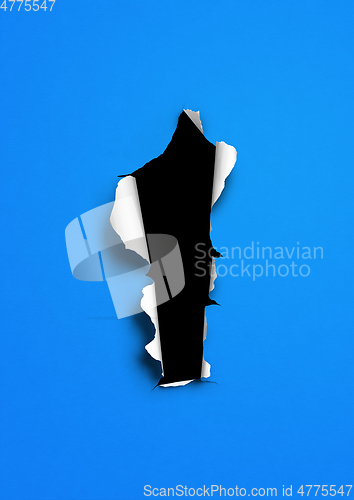 Image of Blue torn paper with black hole