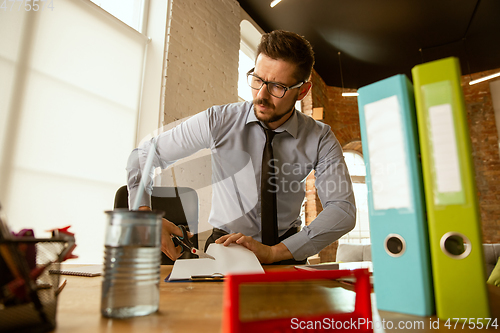 Image of A young businessman moving in office, getting new work place