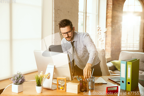 Image of A young businessman moving in office, getting new work place