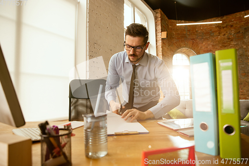 Image of A young businessman moving in office, getting new work place