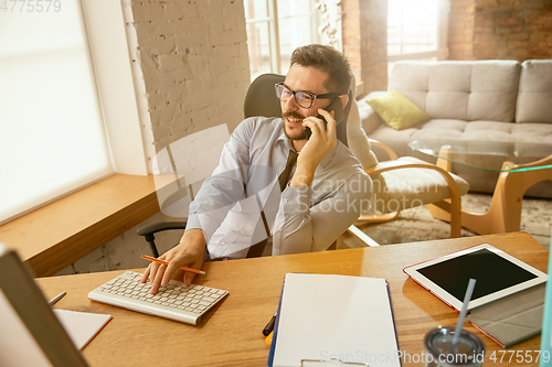 Image of A young businessman moving in office, getting new work place