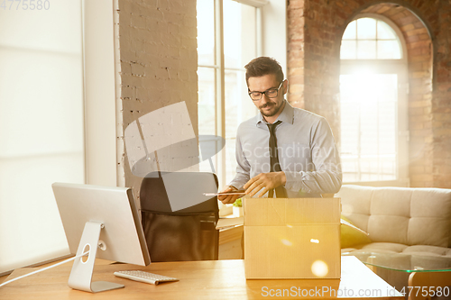 Image of A young businessman moving in office, getting new work place