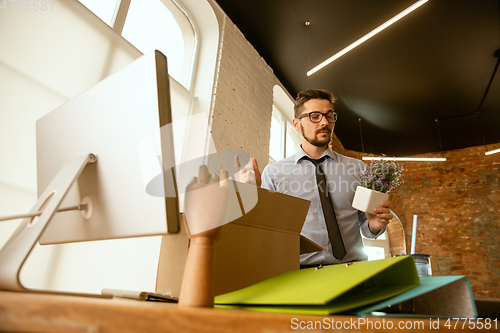 Image of A young businessman moving in office, getting new work place